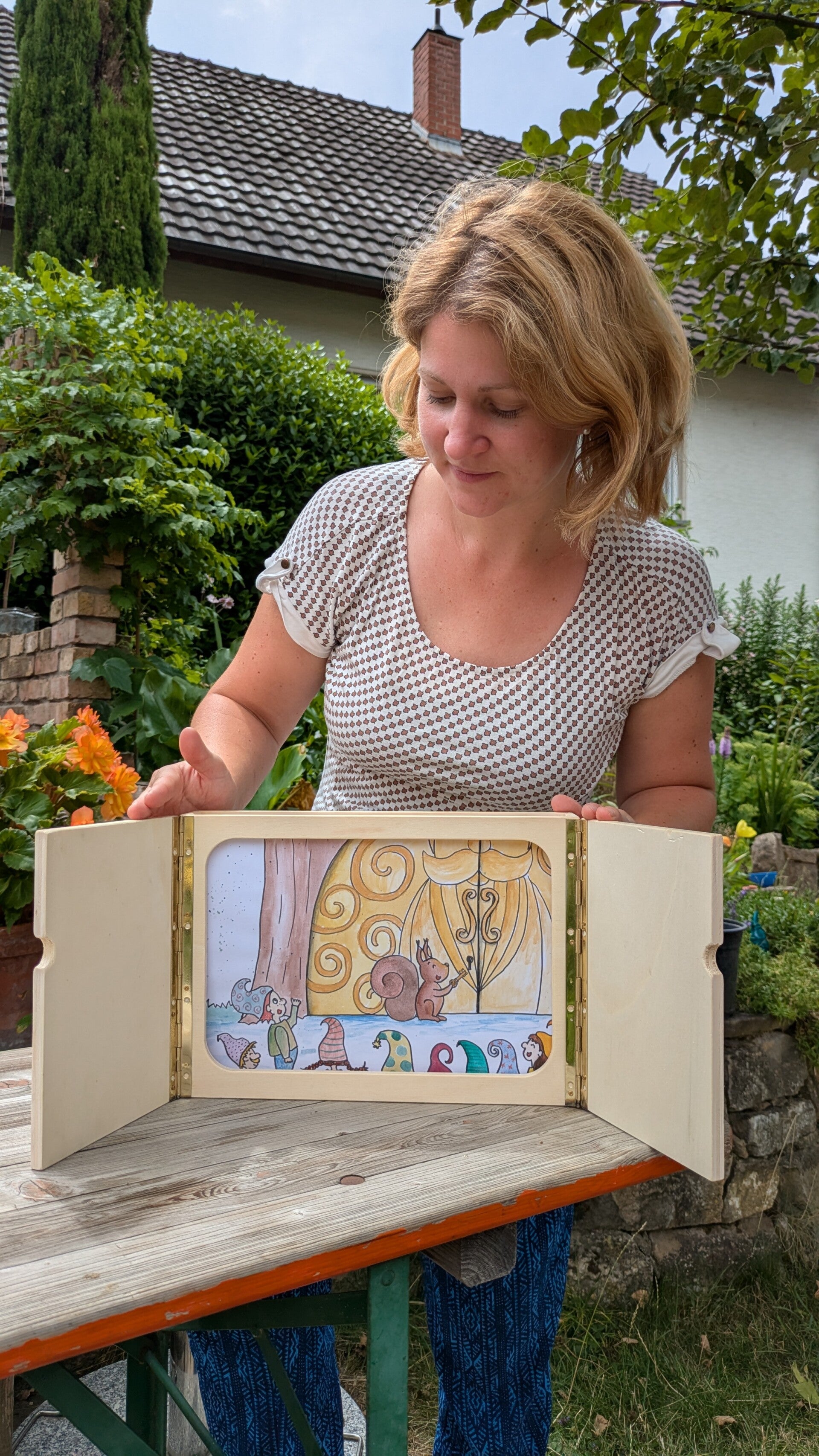 Catherine von hoppiolla in einem hellen, gemusterten Oberteil hinter dem Kamishibai als schlechtes Beispiel