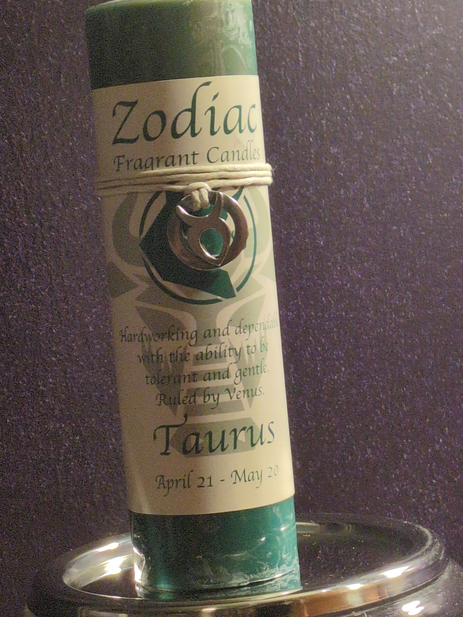 Taurus-themed zodiac pendant candle is decorated with a pewter charm representing the bull symbol.