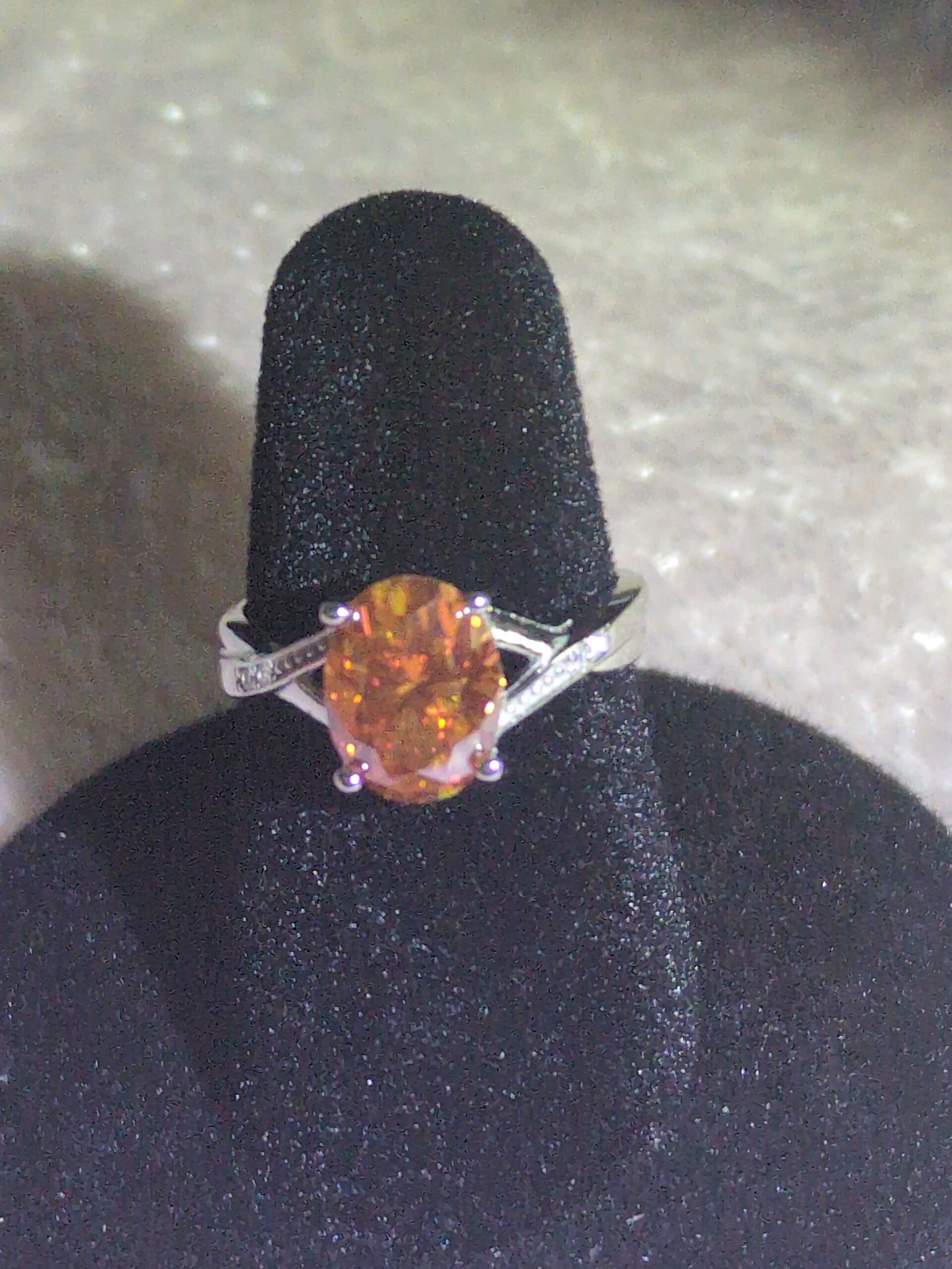 Sz 7 S925 Sterling Silver oval-cut orange moissanite set in a split-shank band accented with Moissanite stones.