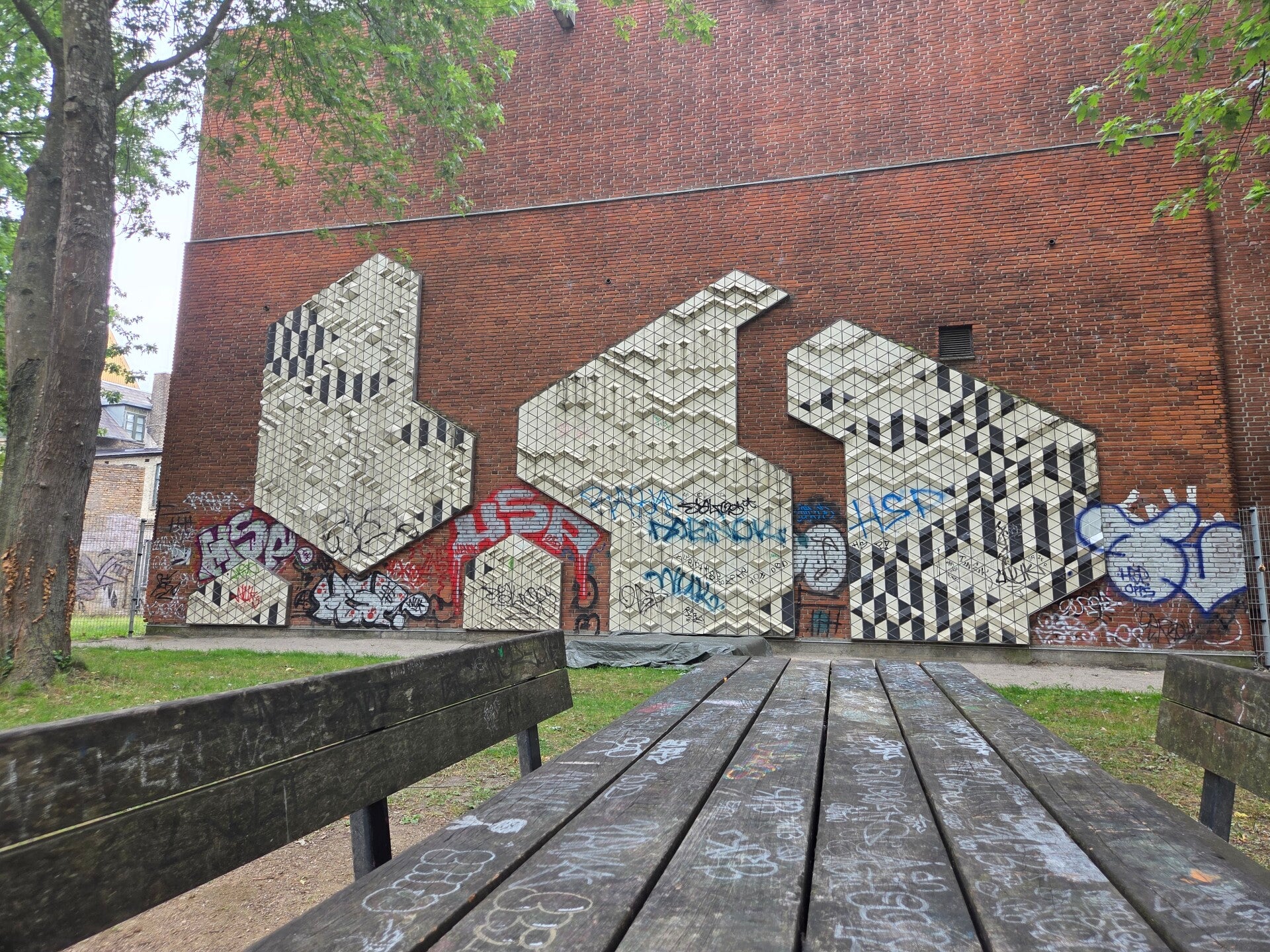 Geometrische kunst en graffiti op een bakstenen muur in een stedelijke omgeving