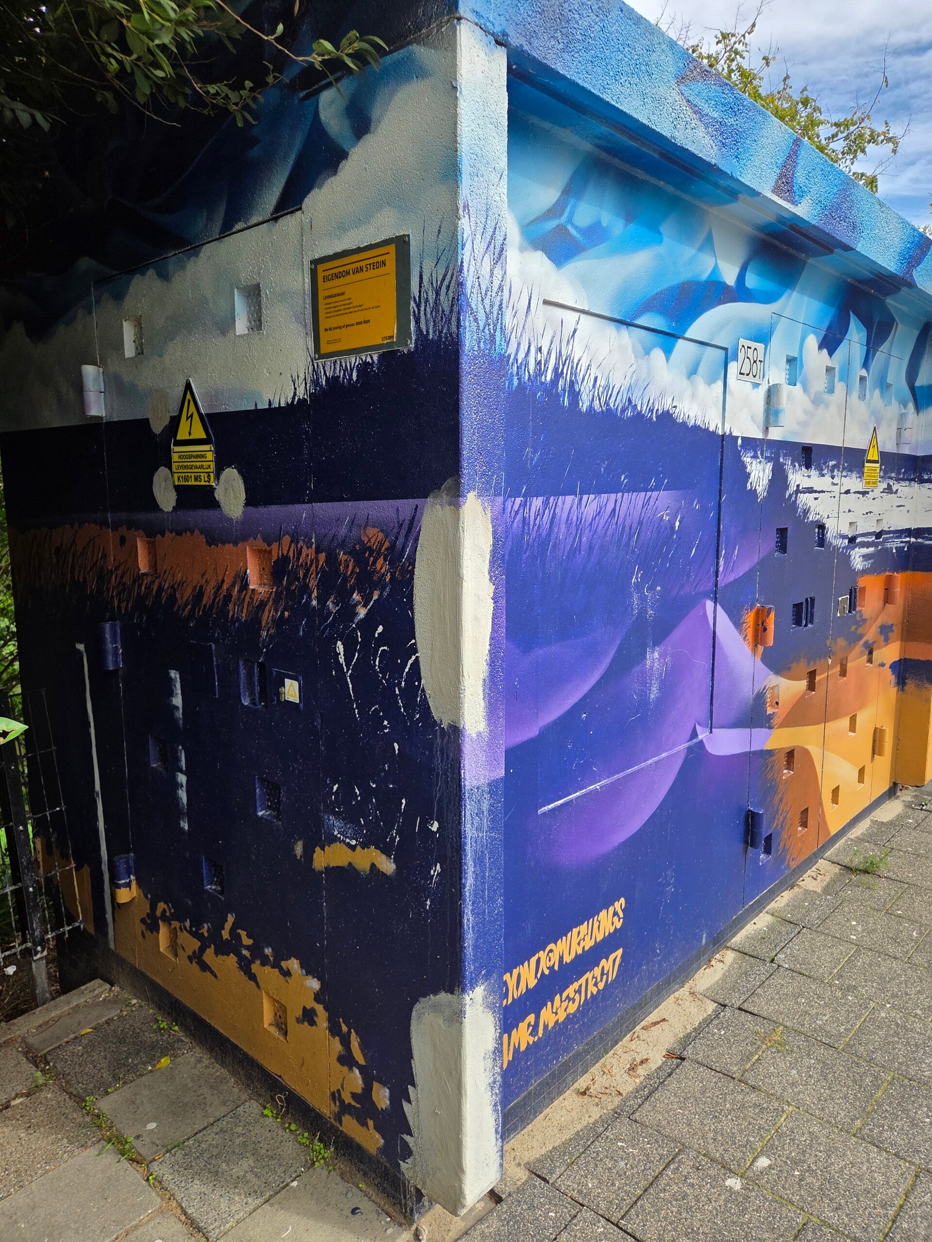 Kleurrijke street art mural op een gebouw met blauwe, paarse en oranje vormen