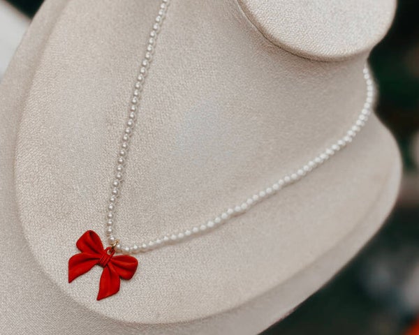 Red bow and pearl necklace
