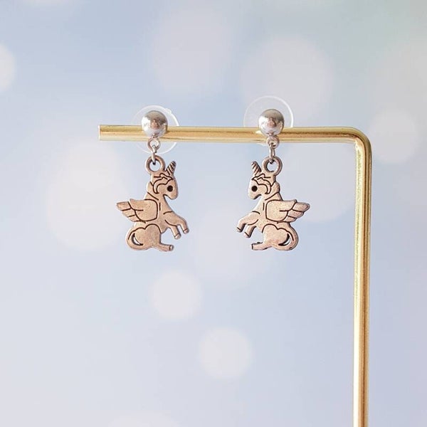 Zilverkleurige oorstekers met unicornhanger.