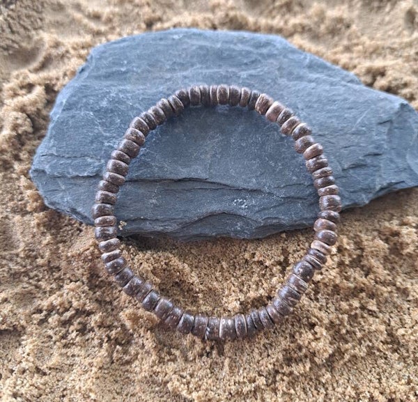 Elastische armband met platte houten kralen, breedte 5mm.