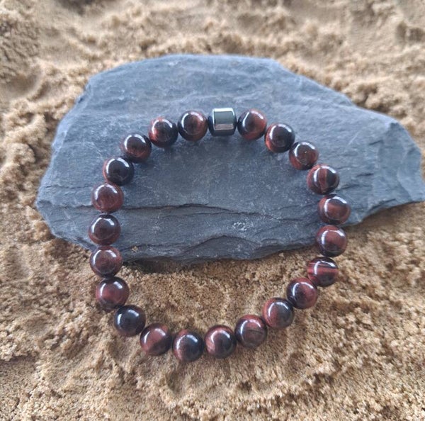 Elastische armband met rode tijgeroog kralen en hematiet kraal.