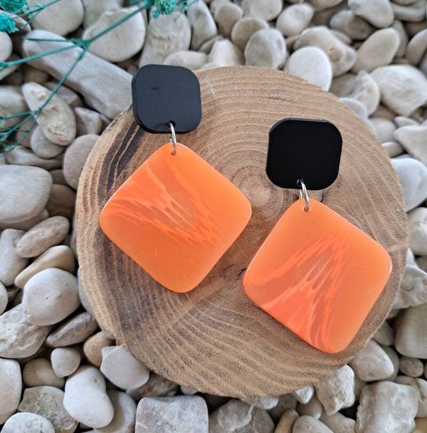 Zwarte stekers met oranje rechthoekige gevlamde hanger.