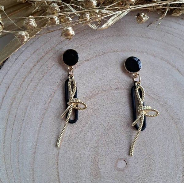 Zwarte oorbellen met gouden strik.