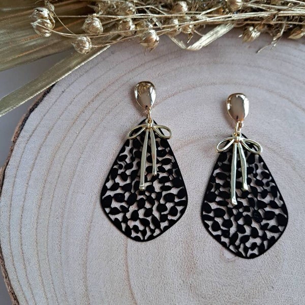 Feestelijke zwarte druppeloorbellen met gouden strik.