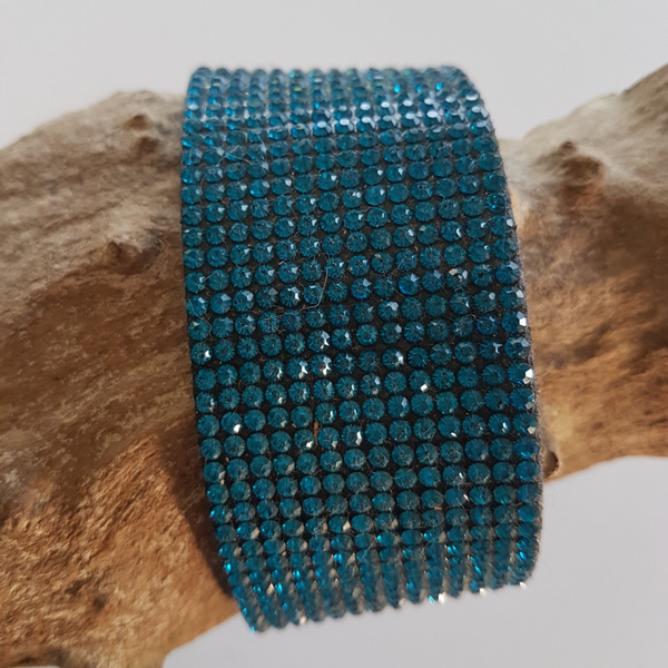 Brede armband in PU leder met 14 rijen blauwe rijnsteentjes.