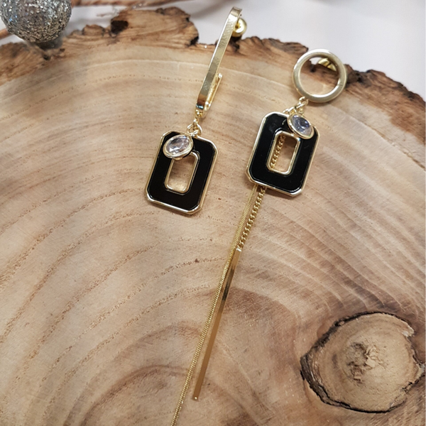 Goudkleurige assymetrische oorbellen met zwarte epoxy hanger.