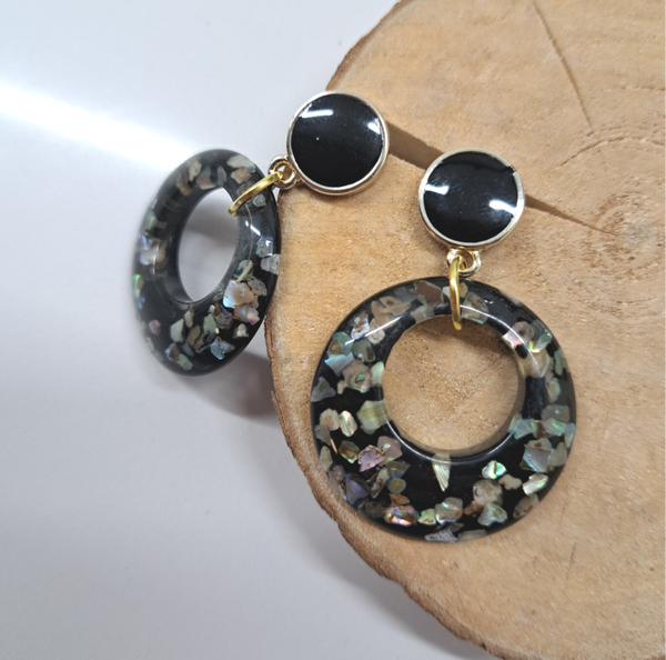 Zwarte stekers voorzien van holle zwarte hanger met goudvlokjes.