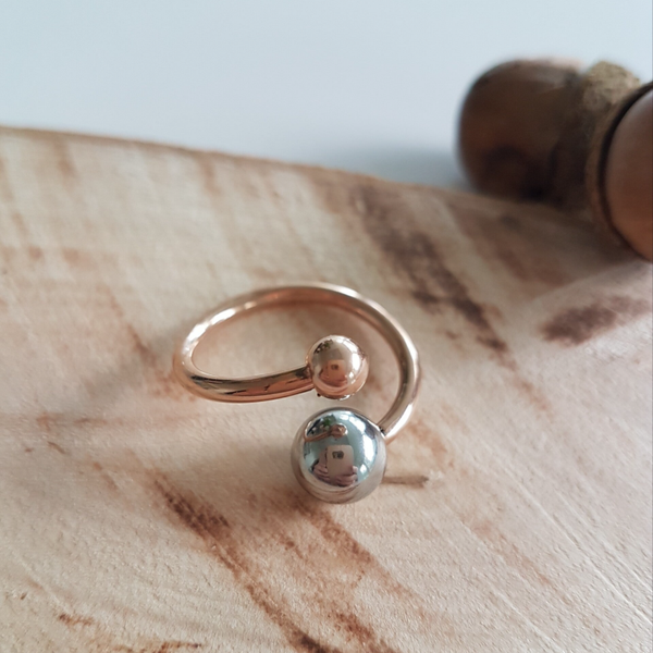 Moderne open ring in roségoud -en staalkleur.