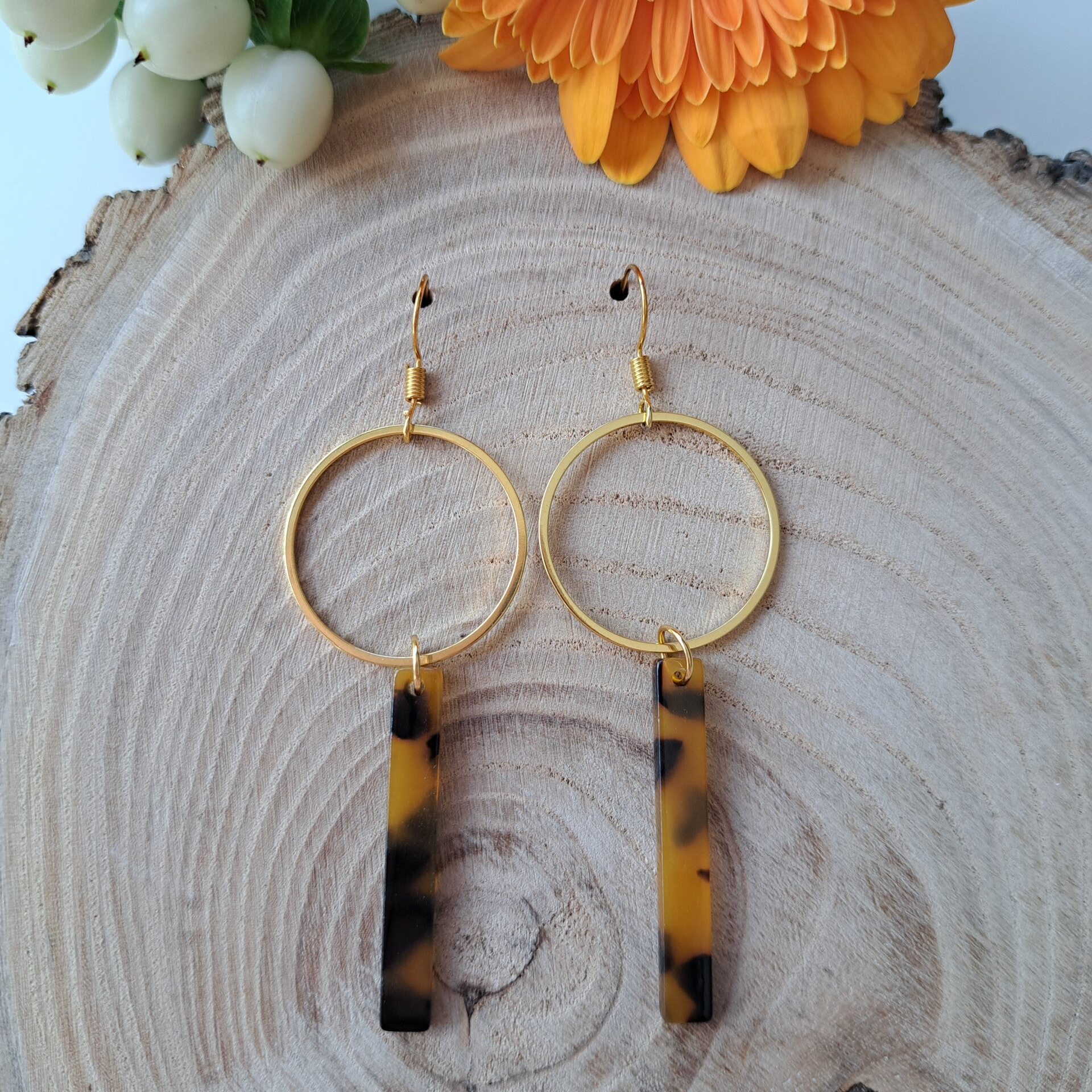 Goudkleurige staafjesoorbellen met luipaardmotief.