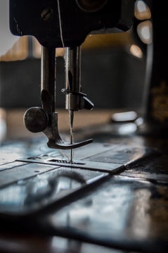 Dark aesthetic picture of an antique Singer sewing machine, needle and presser foot.