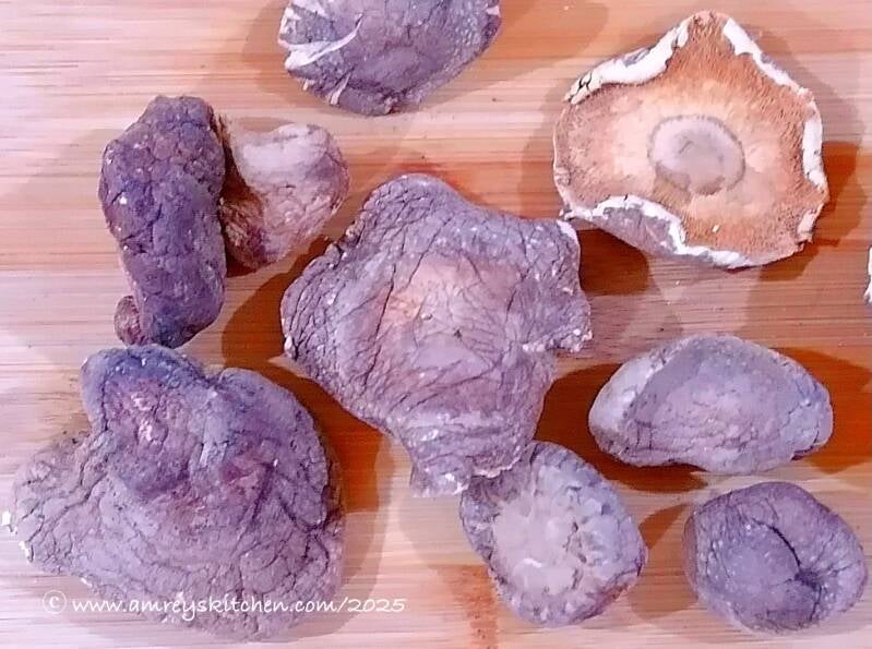 Dried Shiitake mushrooms on a wooden board top view. Photo by Amrey Boquiren of Amrey’s Kitchen™, Kina Amapola™, and Pawntee’s Grub™.