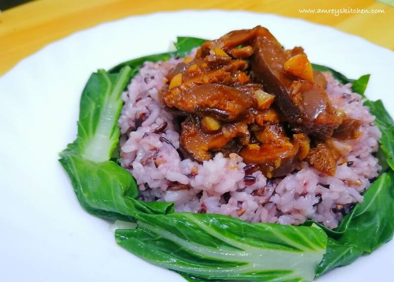 Vegan Shiitake BBQ Stir-Fry on top of wild rice surrounded with blanched pechay on a white porcelain plate. Recipe and photo by Amrey Boquiren for Amrey’s Kitchen™.