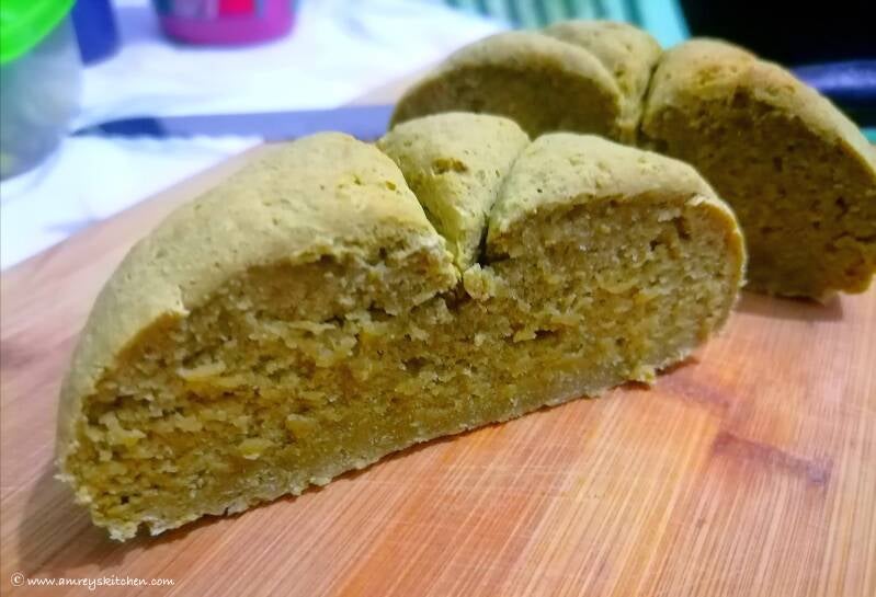 No-Yeast Vegan Moringa Bread sliced in half on a wooden chopping board. Recipe and photo by Amrey Boquiren of Amrey’s Kitchen™.