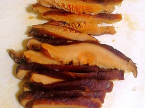soaked shiitake mushrooms cut into strips on a white chopping board. Photo by Amrey Boquiren of Amrey’s Kitchen™, Kina Amapola™, and Pawntee’s Grub™.