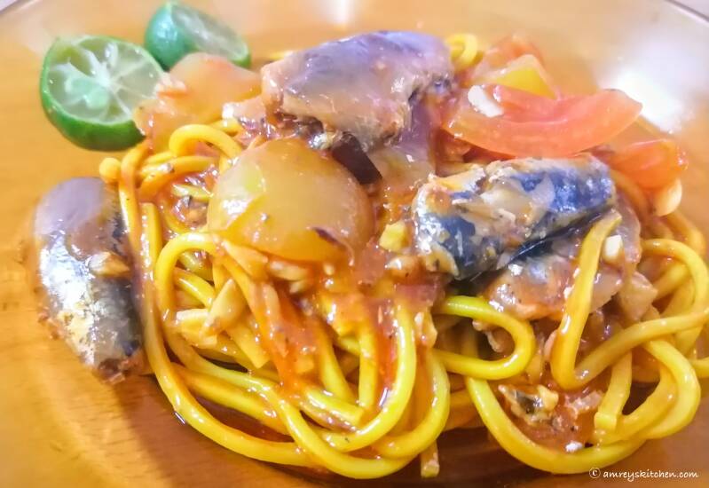 Southern Spaghetti in a brown round shallow dish with sliced calamansi (Udong at Tinapa). Recipe and photo by Amrey Boquiren of Amrey’s Kitchen™.