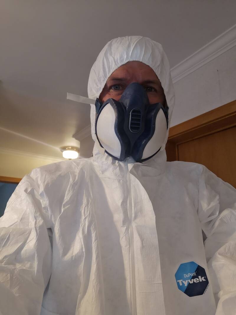 Deskundige asbest voorzien van een mondmasker en beschermingspak.