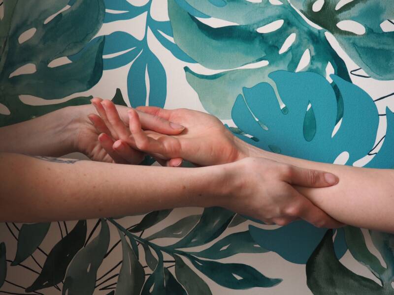 Massage de mains et avants-bras sur fond bleu et blanc