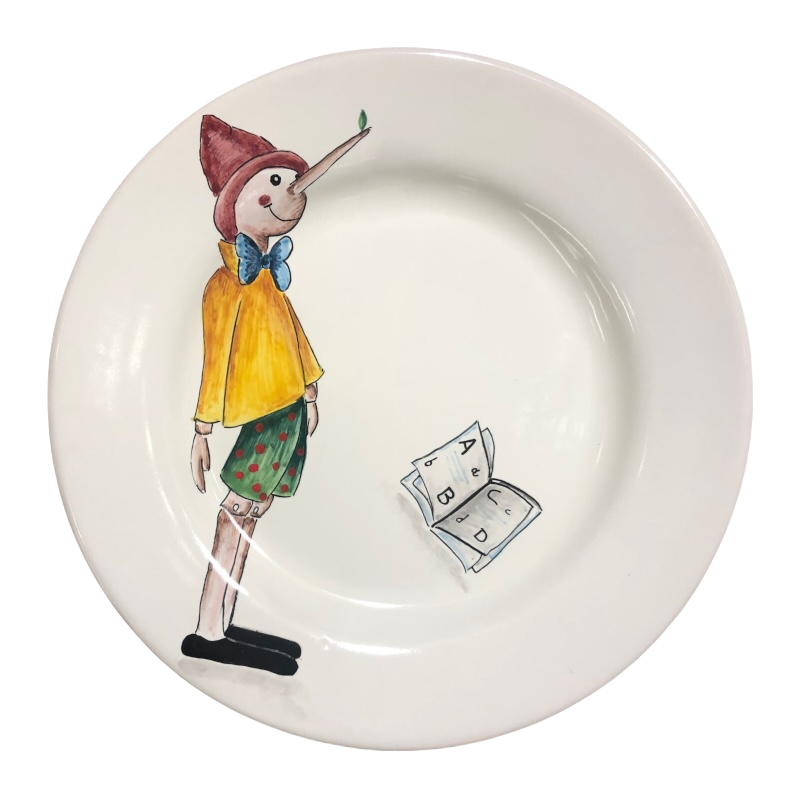 Piatto piano lavorato e dipinto a mano. Diametro 22 cm. Decoro Collezione Pinocchio.