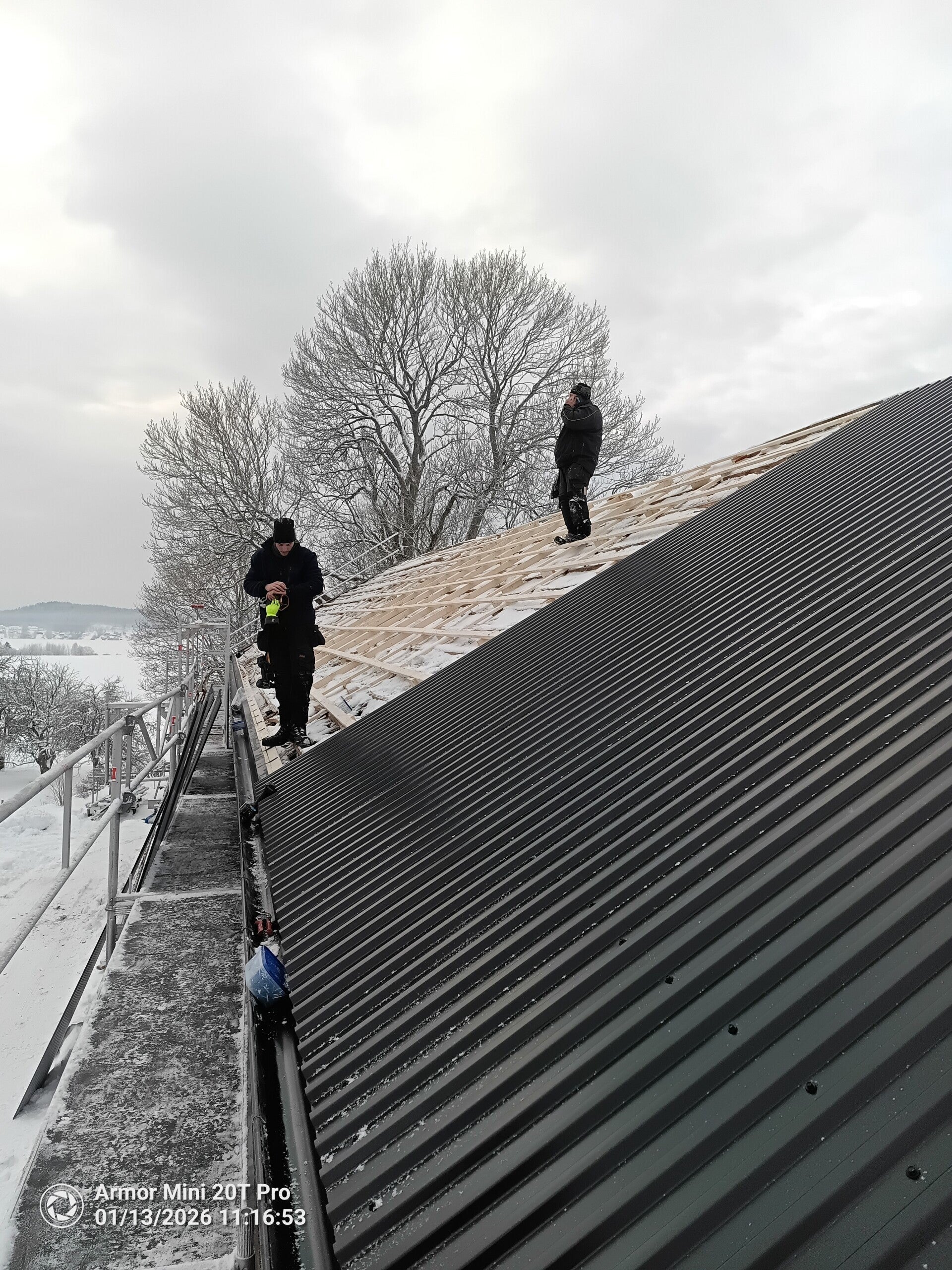 Montering av svart TP20-plåttak på ett takprojekt i Dalarna