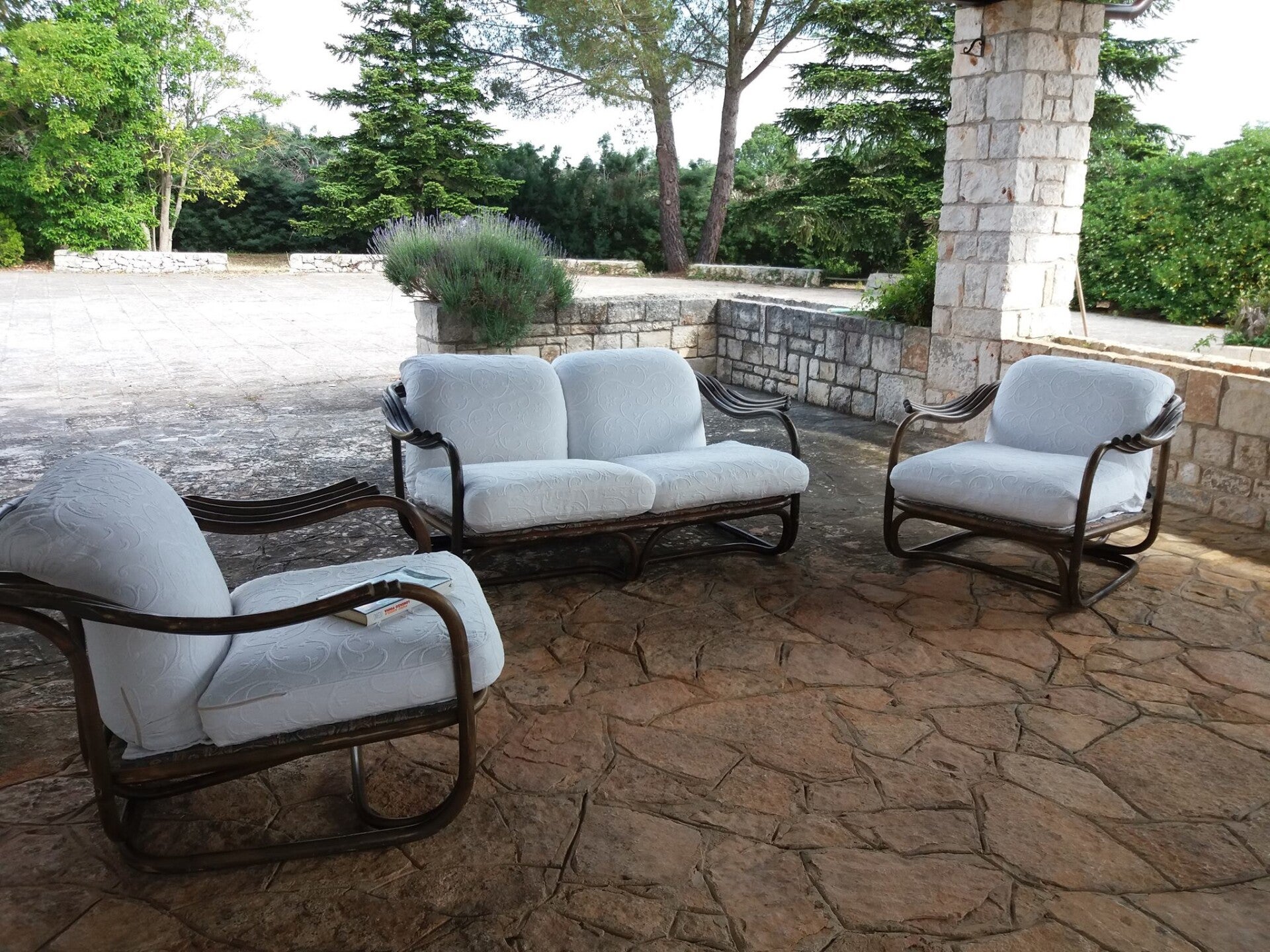 Veranda arredata con salotto confortevole, poltrone e divano per momenti di relax all’aperto