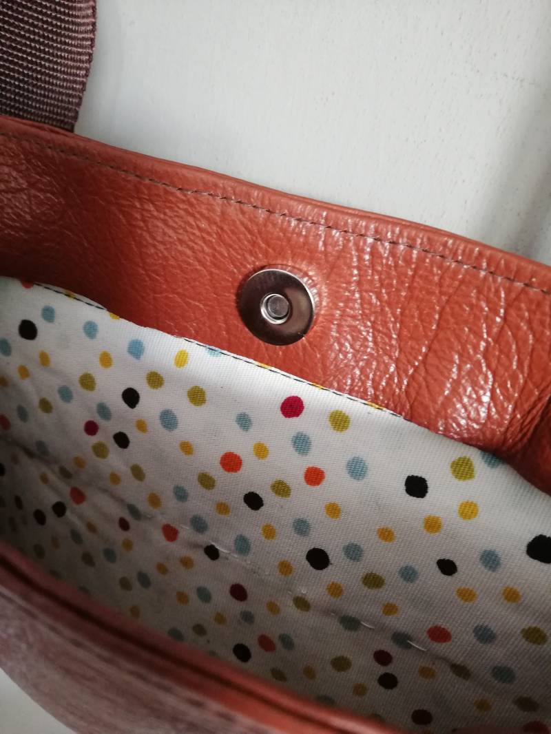 zicht in tas van oranjebruine leren schoudertas van hergebruikt leer