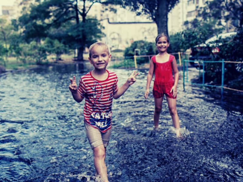 jongen en meisje spelen in de regen