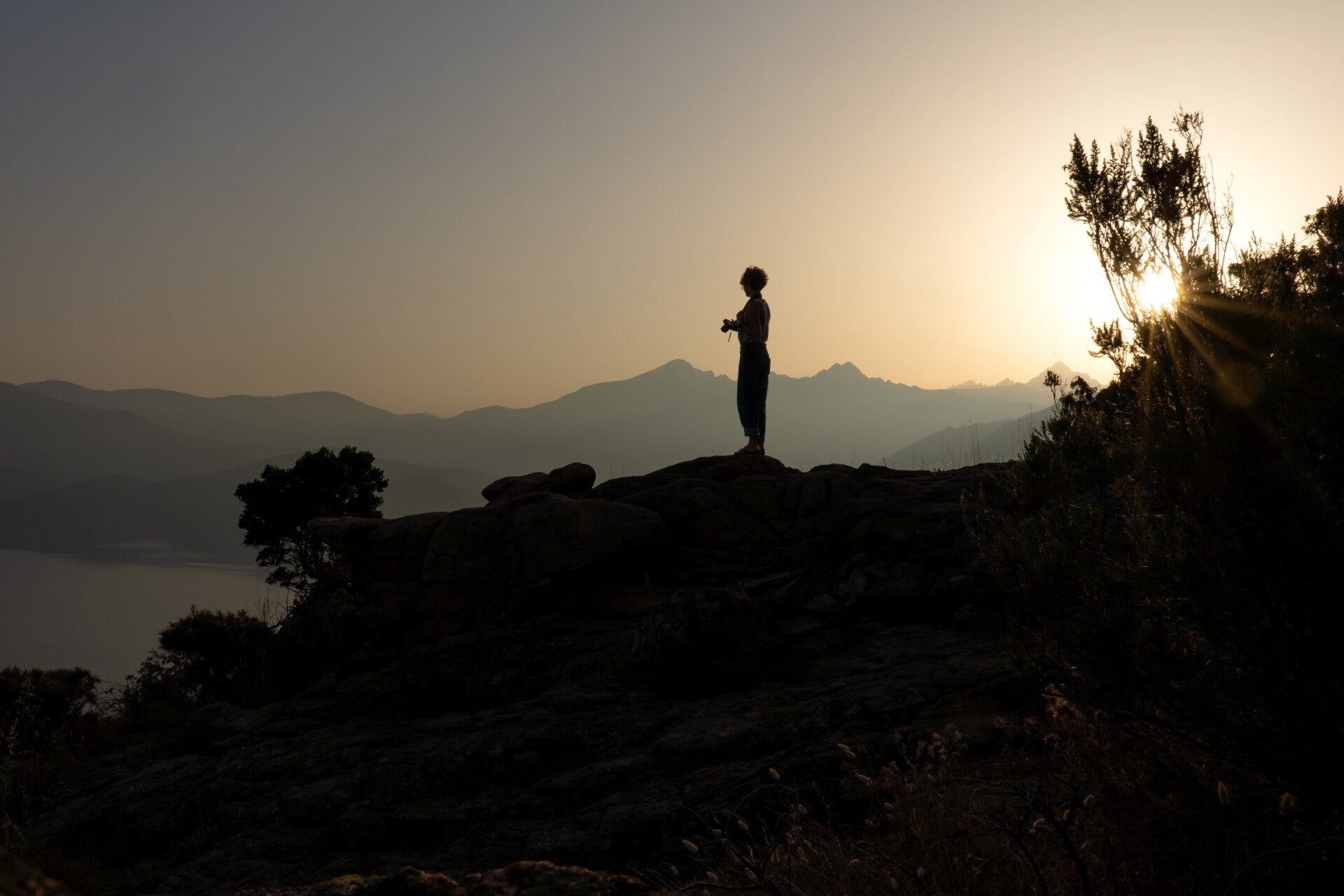 Fotografin Karina Sikora mit Kamera beim Sonnenaufgang auf Korsika mit traumhafter Aussicht