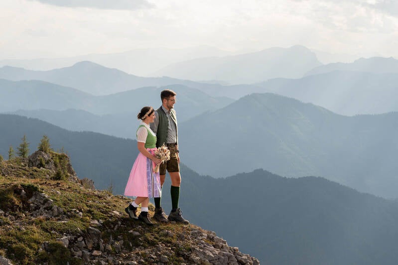 Elopement Steiermark – Brautpaar in Tracht auf einem Berg im Hochschwabgebiet mit Blick über die Landschaft