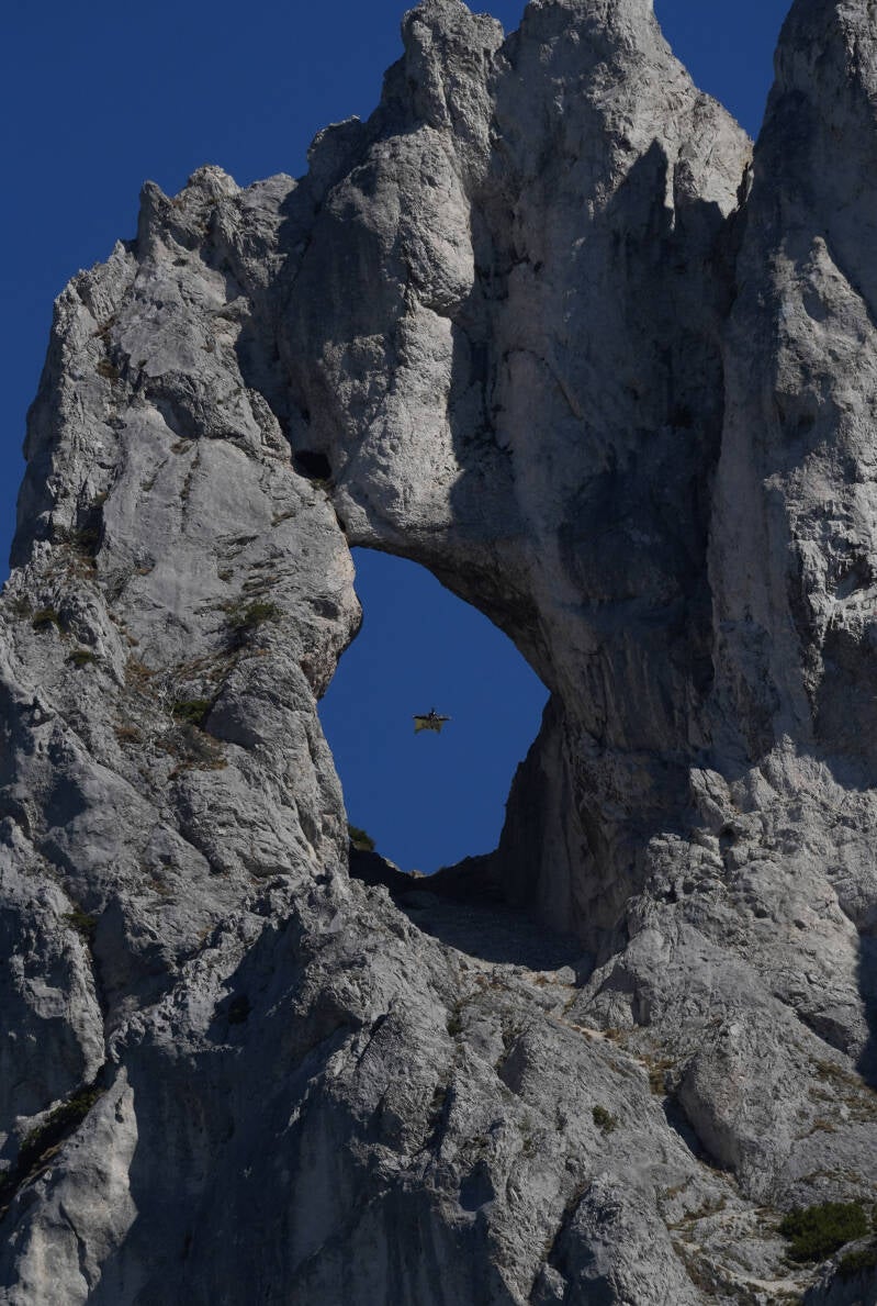Wingsuit-Pilot beim Flug durch das Messnerinnenloch im Hochschwabgebiet
