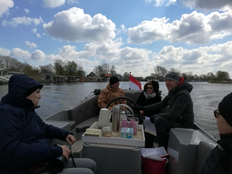 Hier zie de sloep in Actie mooie heldere wolkenlucht en alle deelnemers dik ingepakt in winterjassen. Thermoskannen met thee en koffie om op te warmen staan klaar op de motorkist, tijdens deze rondvaart zo vroeg in het seizoen.