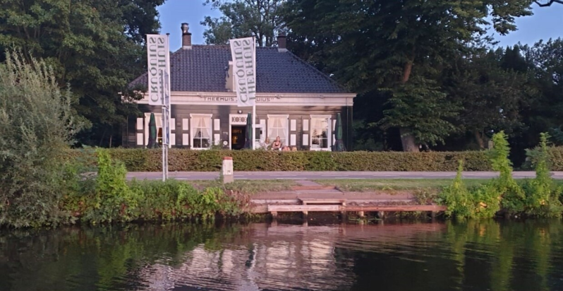 Je ziet hier Theehuis Cruquius met aan de waterkant de vernieuwde steiger voor het makkelijk opstappen voor een Aqua volta rondvaart.