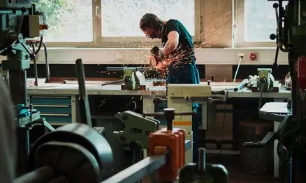 Medewerker slijpt metalen onderdeel tijdens technisch onderhoud in werkplaats van Werotech Techniek