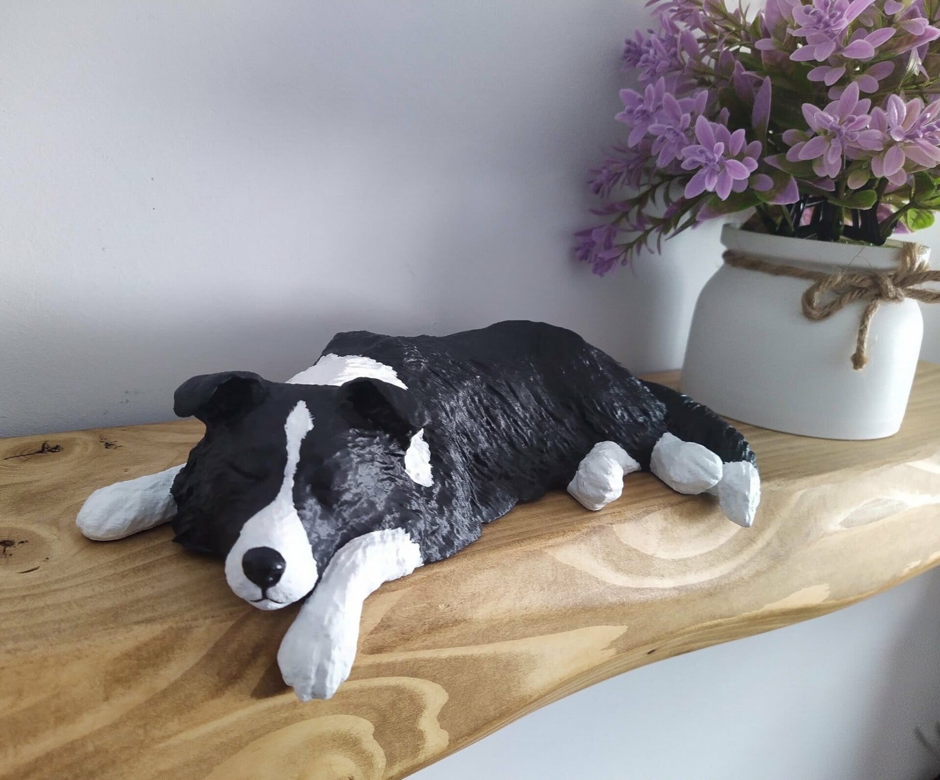 Highland cow ornament in bronze effect lying down on a shelf sleeping..