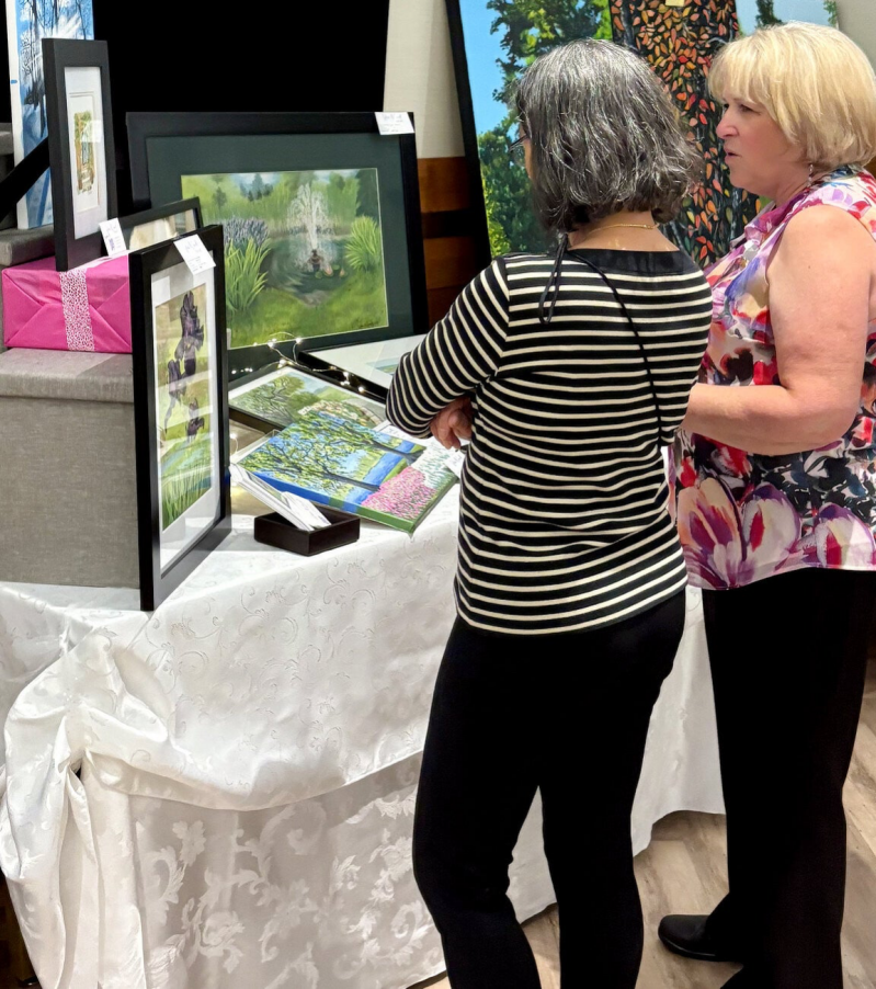 Sylvia McConnell speaking with a visitor at an art show