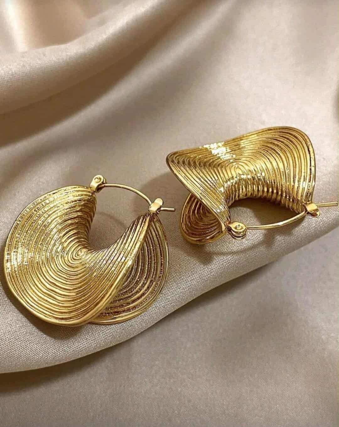 Un pair de boucles d’oreilles créole épaisses dorés