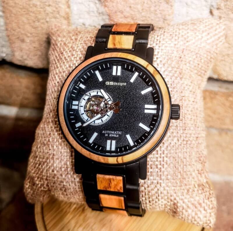 Orologio JAH automatico con movimento a vista sul quadrante (open heart), combinato con una cassa e cinturino in legno scuro.