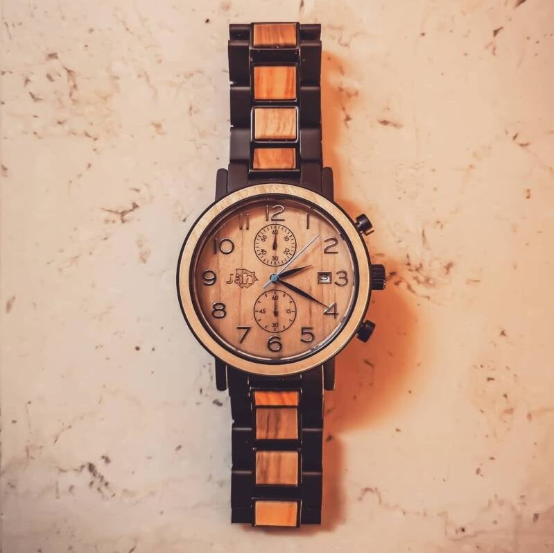 Orologio cronografo bicolore in legno chiaro e scuro, con quadrante chiaro e lancette a contrasto.