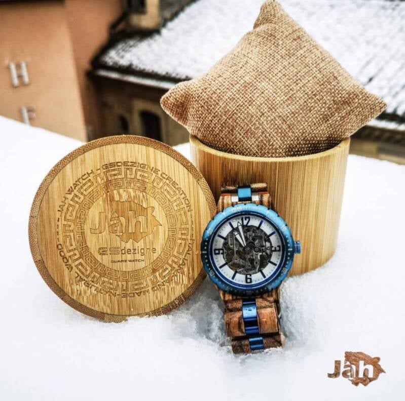 Orologio artigianale con cassa in legno e dettagli blu, presentato nell'esclusivo cofanetto regalo con coperchio inciso.