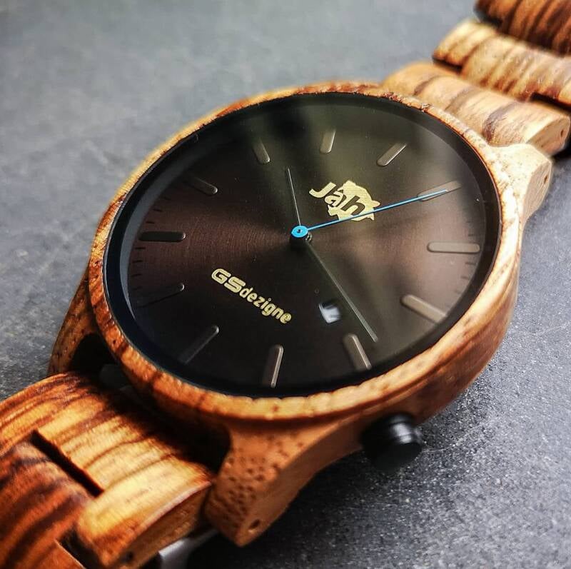 Dettaglio ravvicinato del quadrante minimalista dell'orologio JAH in legno chiaro, con cassa ben definita.