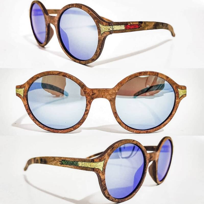 Un tuffo nel passato con un tocco naturale: occhiali da sole rotondi in legno stile vintage, completati da eleganti lenti azzurre a specchio.