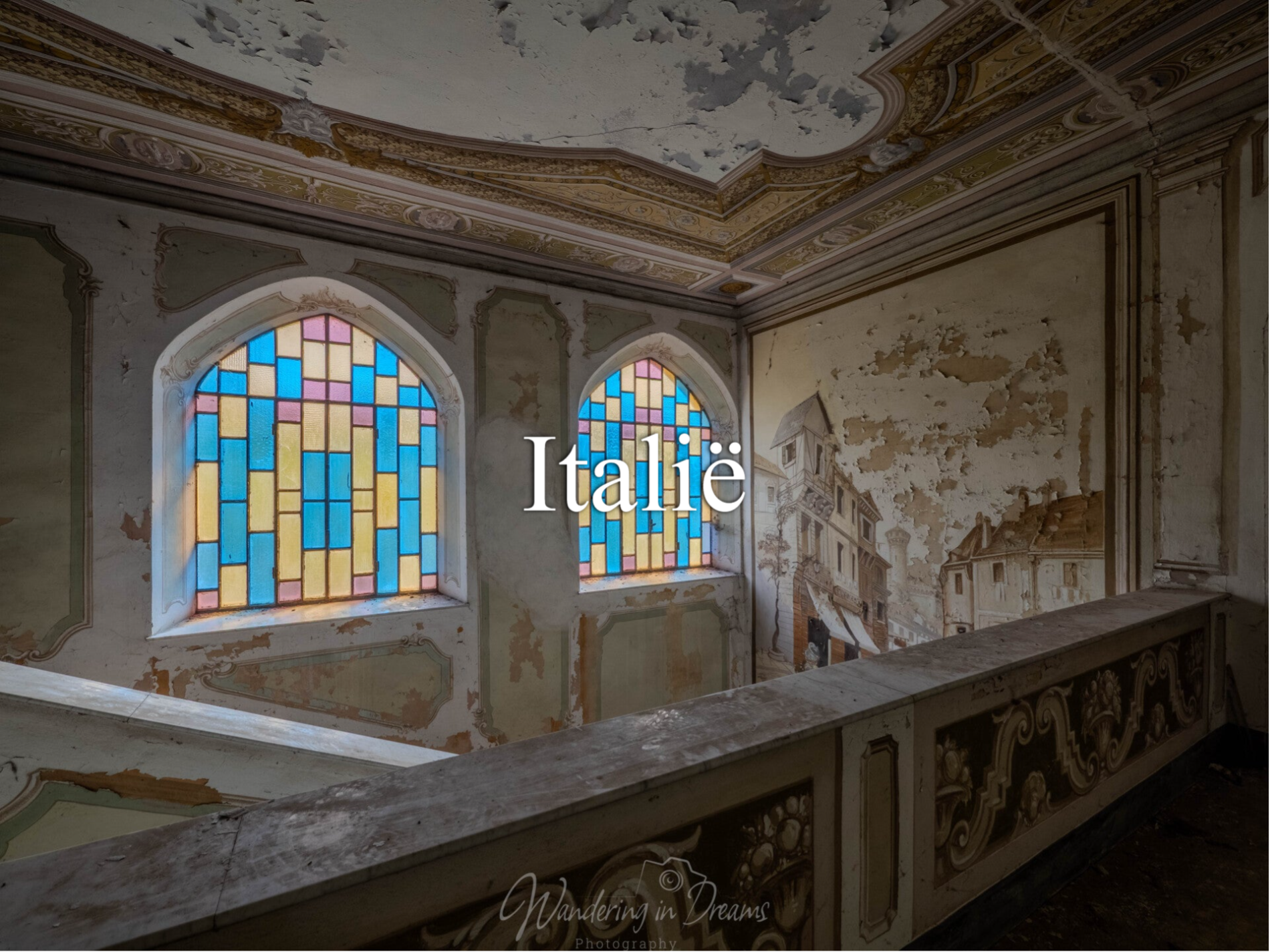 Trappenhal in verlaten gebouw met kleurrijke rood geel en blauw glas in loodramen en prachtige muur en plafondschilderingen in urbexomgeving