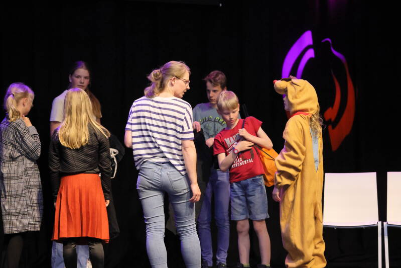 Theaterles voor kinderen. Op de foto staat José met een aantal kinderen en tieners in kostuum.