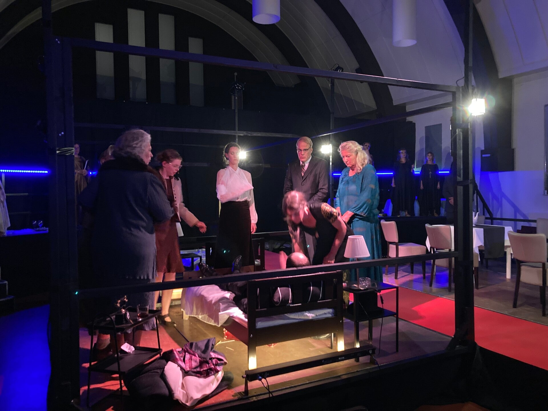 Regisseren. Op de foto staat José op het podium. Twee tieners staan en zitten ook op het podium.