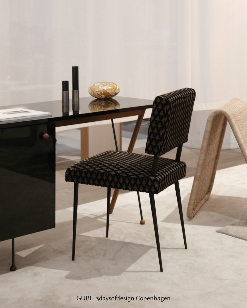 GUBI collection presentation with a black chair and dark table elements, showing black as line, silhouette and furniture structure.