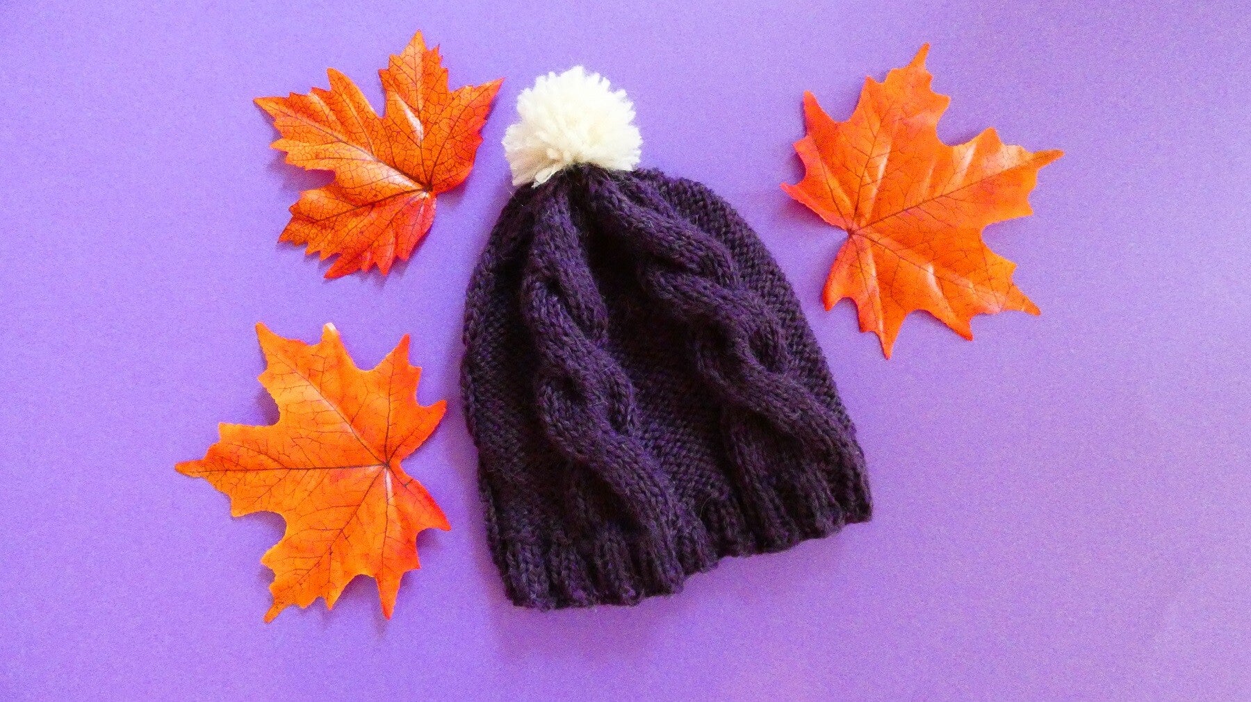 Le bonnet torsades violet à pompon 2 ans