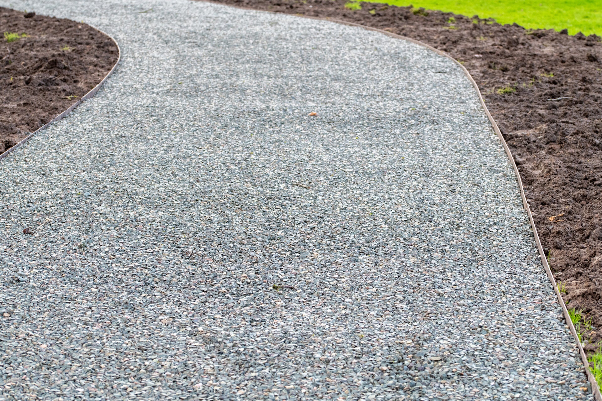 Stone gravel evenly spreaded across a dirveway 